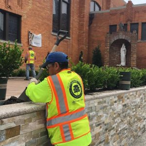 Man in a safety vest diligently working on a wall, ensuring safety and precision