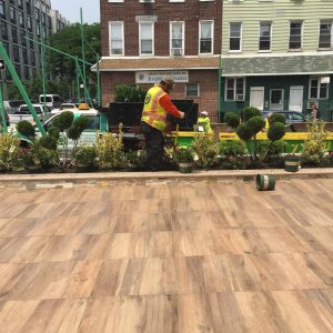 Man in a yellow vest is diligently working on a patio